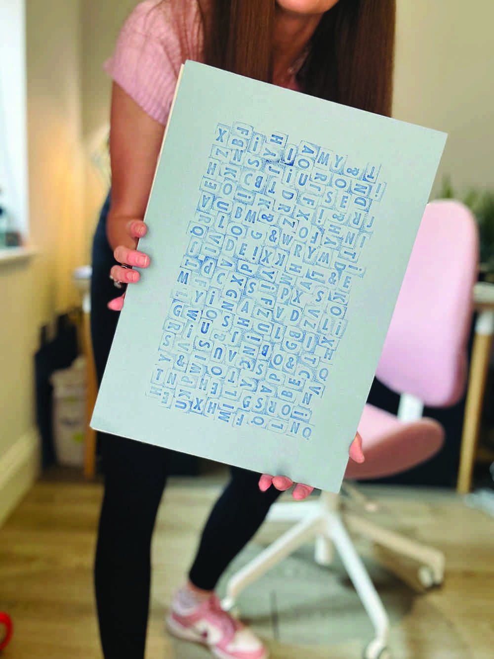 Lady holding blue typography artwork